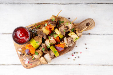 Grilled skewers with meat and vegetables. Delicious roasted beef meat, champignon mushrooms,...