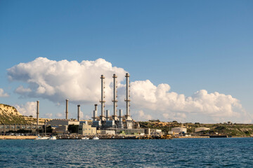 Waterfront power station against blue sky, with copy space, Marsaxlokk, Malta