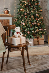 Home New Year's interior. Christmas tree with gifts, decorated with garlands in the kitchen. Cozy atmosphere of a home holiday, loft design of the room, Scandinavian style.
