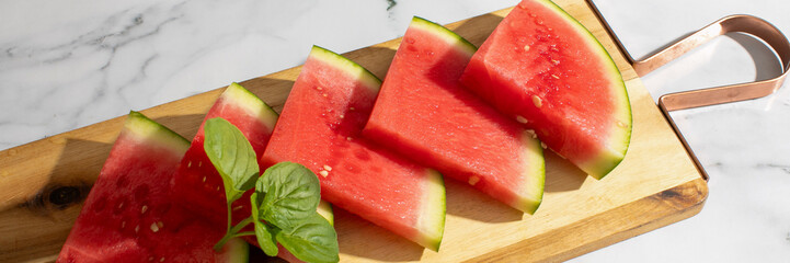 Vibrant slices of watermelon basking in sunlight evoke summer solstice picnics and refreshing...