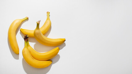 Golden bananas basking in sunlight evoke World Banana Day, tropical abundance, and nutrient-rich...