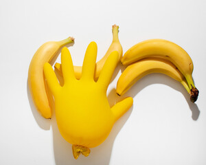 Quirky banana quartet juxtaposes inflating latex glove, evoking whimsical culinary wonders and...