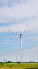 A solitary wind turbine dances atop verdant hills, evoking Earth Day whispers and Ecolution...