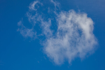 Fluffy cloud whispering cryptic tales in cobalt sky, reminiscent of Dream Day contemplation and...