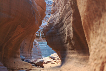 A group of explorers navigates through stunning rock formations in a canyon during a bright day,...