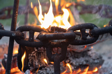 Closeup of Metal Chain Links Glowing Against the Bright Flames of a Fire