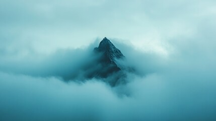 Majestic Mountain Peak Emerging Through Thick Morning Clouds
