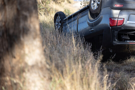 Damaged and overturned car on the roadside