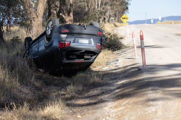 Damaged and overturned car on the roadside