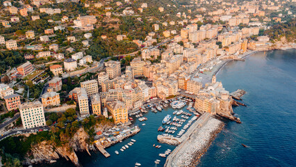 Obraz premium Camogli, liguria: colorful buildings overlooking the mediterranean sea at sunset