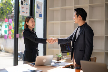 A woman shakes hands with a man in a suit