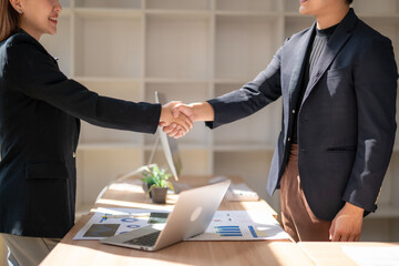 Two people shaking hands in a business setting