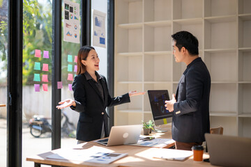 Fototapeta premium A woman and a man are talking in a room with a computer monitor