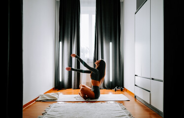 Young woman practices yoga indoors during the day for relaxation and mindfulness