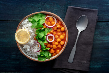 Chana masala, chickpea curry, traditional Indian dish, overhead flat lay shot with a spoon