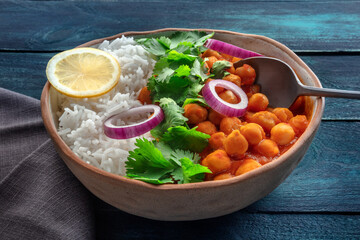 Chana masala, chickpea curry, traditional Indian dish. Healthy vegan food on a dark blue background