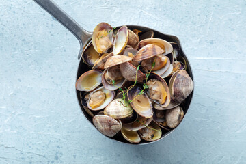 Vongole clams in a saucepan with thyme, overhead flat lay shot. Seafood sauce, Mediterranean cuisine