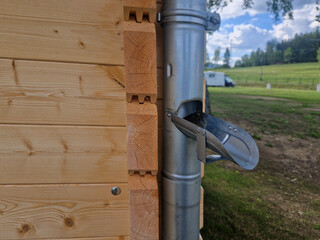 The gutter on a wooden log cabin is equipped with a pipe and a drainage chute, the sheet metal...