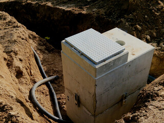 Installation of concrete tanks painted with black insulating asphalt paint. the ring entrances look...