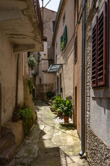 Walking among the monuments of the old town of Vrbnik, a tall tower with a clock in the center of the old town of Vrbnik on the island of KRK,