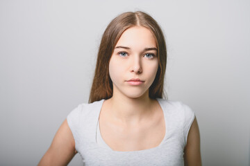 Portrait of teenage girl in casual t-shirt on light background in studio.