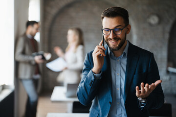 Businessman speaking on his smartphone in office