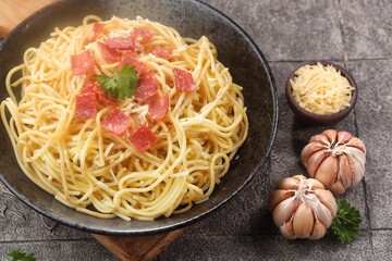 Spaghetti Carbonara is an Italian dish consisting of spaghetti pasta cooked with heavy cream sauce, cheese and meat.