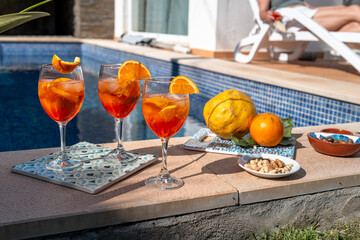 Obraz premium Summer drinks and citrus fruit arranged beside the pool