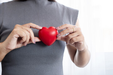 Closeup of woman hand holding a red heart shaped object, representing heart health awareness, early medical checkups, cardiology care and reminders for World Heart Day