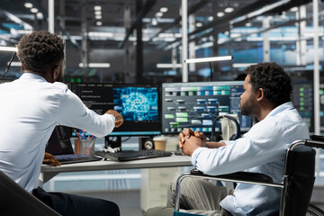 Server room manager and employee in wheelchair use artificial intelligence to perform computing...