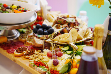 A large served table with salads, vegetables and barbecue, treats and snacks