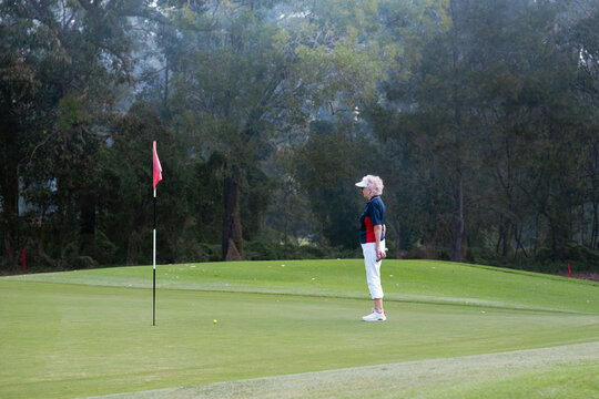 senior woman looking at the final hole at a golf course
