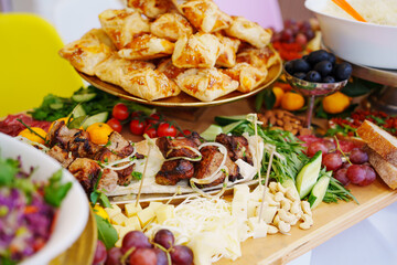 A large served table with salads, vegetables and barbecue, treats and snacks