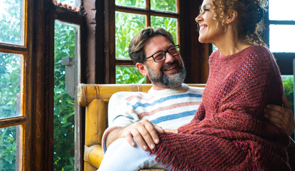 Mature couple in their 40s sharing affection at home or in a cozy vacation chalet. A moment of...