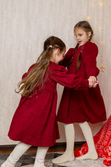 Happy positive kids have fun on Christmas day at home. Children dance to New Year music during...