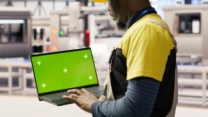 Solar panels factory engineer analyzes performance data with green screen laptop to predict gear...