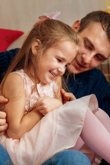 Dad and daughter tickling and playing together in the Christmas