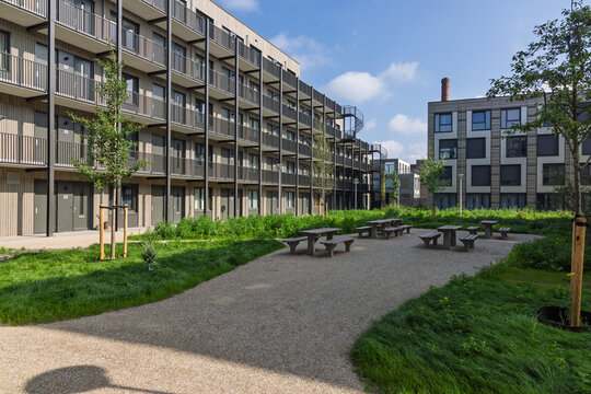 A communal courtyard with picnic tables amidst temporary modular homes in Utrecht, Netherlands, illustrating a modern solution to urban housing shortages.
