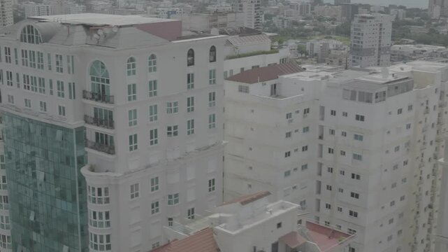 Santo Domingo, Dominican Republic &ndash; June 22, 2025: Aerial drone footage capturing a large modern building with the city skyline of Santo Domingo in the background, 4k raw color video.