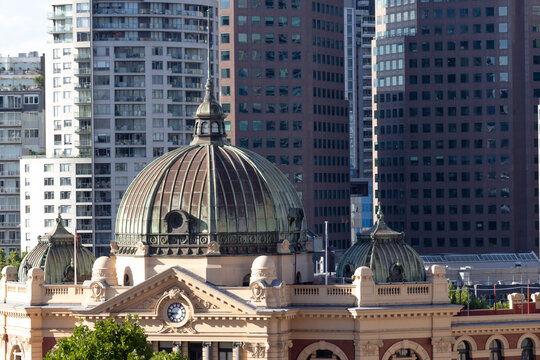 Flinders street station foreground and high rise buildings in background of Melbourne's CBD