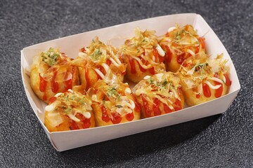 Takoyaki is a typical Japanese snack in the form of small balls made from wheat flour dough and filled with pieces of octopus.