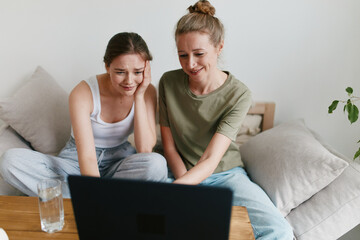 middle age woman and young woman using laptop together, promoting active and healthy lifestyle,...