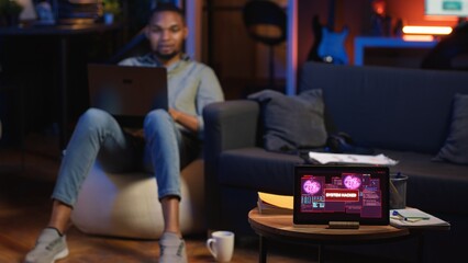 Black IT professional in loft working on cybersecurity with gadgets, tackling hacking attempts,...