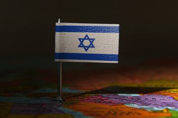 Israel flag pin placed on a map, symbolizing location, politics, or national identity.