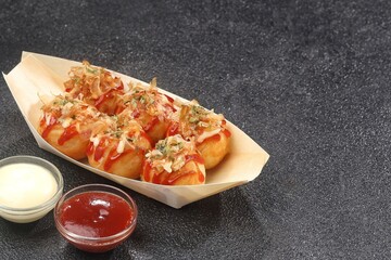 Takoyaki is a typical Japanese snack in the form of small balls made from wheat flour dough and filled with pieces of octopus.