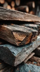 Fototapeten Stacked firewood with textured surfaces in a rustic setting during late afternoon © Michael