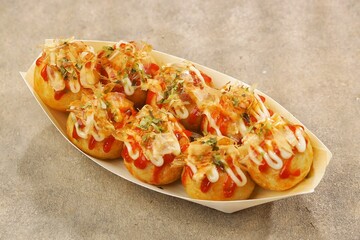 Takoyaki is a typical Japanese snack in the form of small balls made from wheat flour dough and filled with pieces of octopus.