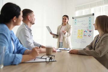 Woman giving public speech in front of audience indoors