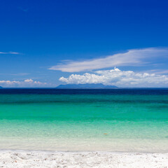 Koh Adang, Thailand. Crystal-clear turquoise emerald green sea touches sandy beach under blue sky. Tropical paradise landscape.