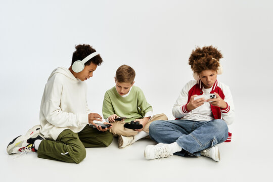 Three stylish little boys enjoying gaming together while showcasing their vibrant fashions - Powered by Adobe